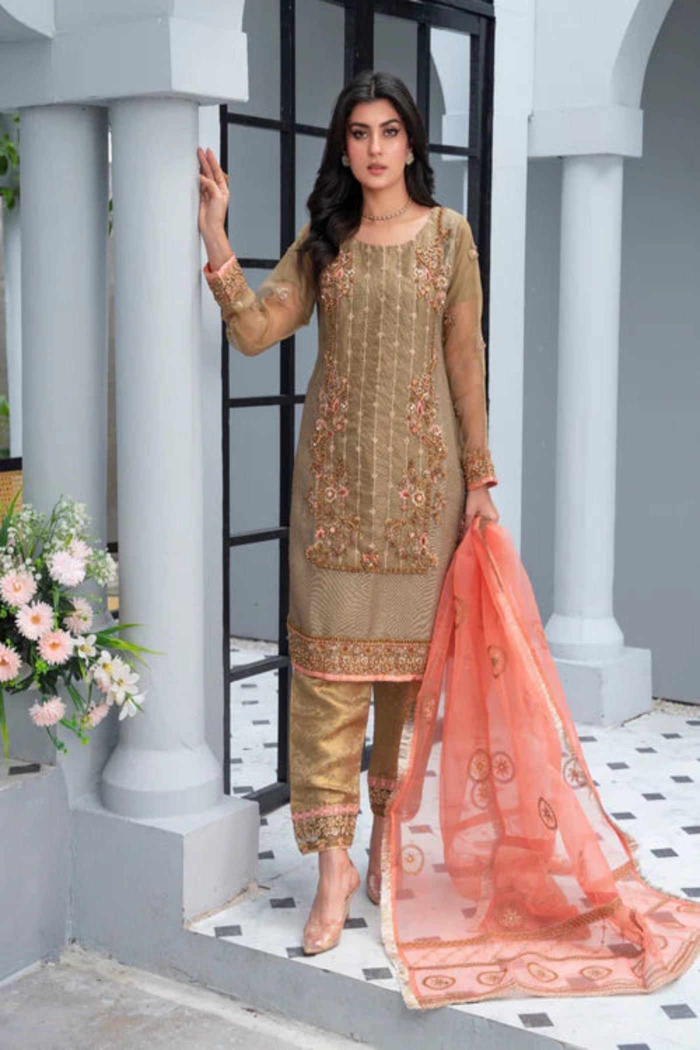 A woman wearing a brown traditional Eastern outfit with embroidery and a dupatta.